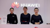 Attendants stand at a Huawei booth at the World 5G Exhibition in Beijing