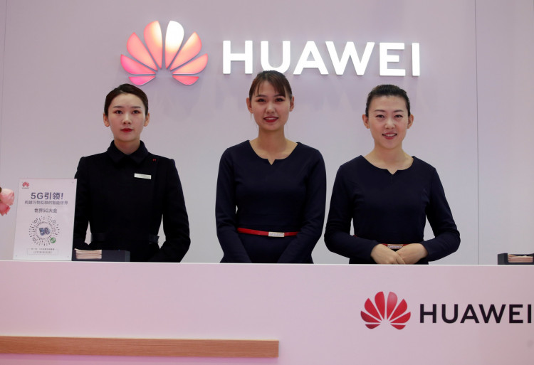Attendants stand at a Huawei booth at the World 5G Exhibition in Beijing