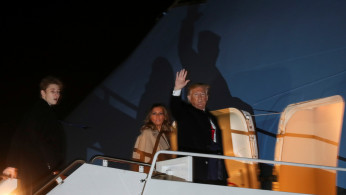 U.S. President Donald Trump waves as he boards the Air Force One with first lady Melania Trump and son Barron after signing the 