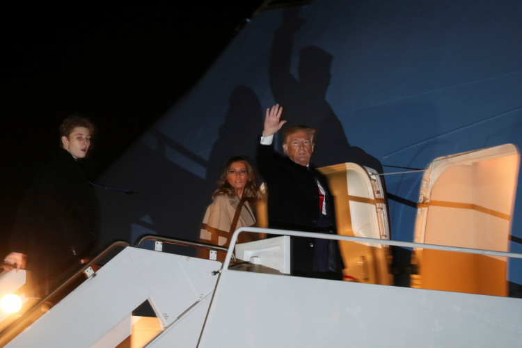 U.S. President Donald Trump waves as he boards the Air Force One with first lady Melania Trump and son Barron after signing the "National Defense Authorization Act for Fiscal Year 2020" at Joint Base Andrews