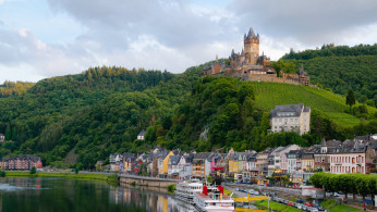 Castle on Hill over Village Near Body of Water.