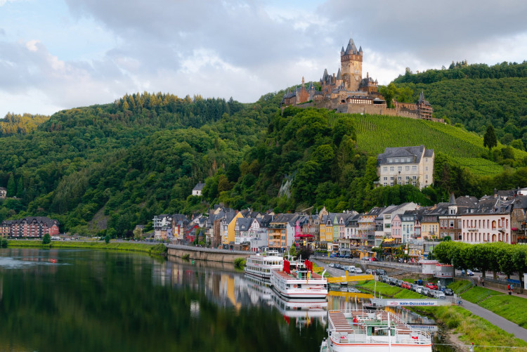 Castle on Hill over Village Near Body of Water.