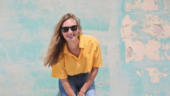 Woman wearing yellow polo shirt.