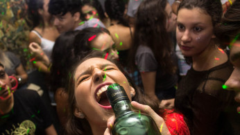 Woman wearing red shirt drinking.