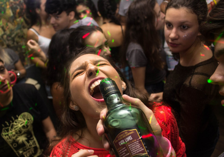 Woman wearing red shirt drinking.