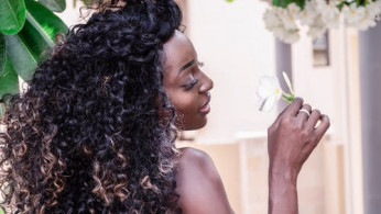 Woman holding white plumera flower.