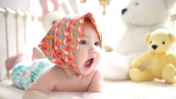 Toddler wearing scarf in the head.