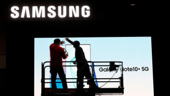 FILE PHOTO: Workers set up a Samsung display in the lobby of the Las Vegas Convention Center in preparation for the 2020 CES trade fair in Las Vegas