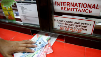 Philippine Peso bills sent by a Filipino working abroad are pictured being received by a relative at a money remittance center in Makati City, Metro Manila, Philippines,
