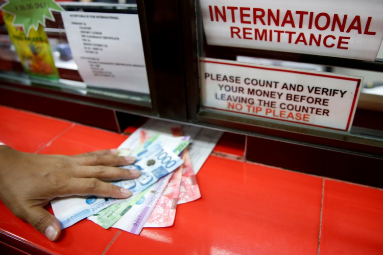Philippine Peso bills sent by a Filipino working abroad are pictured being received by a relative at a money remittance center in Makati City, Metro Manila, Philippines,