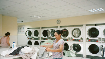 Photo of a woman washing her clothes. 