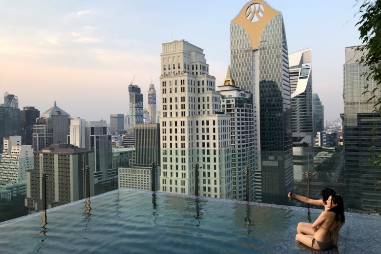 Tourists enjoy a swimming pool at a hotel in central Bangkok, Thailand, 