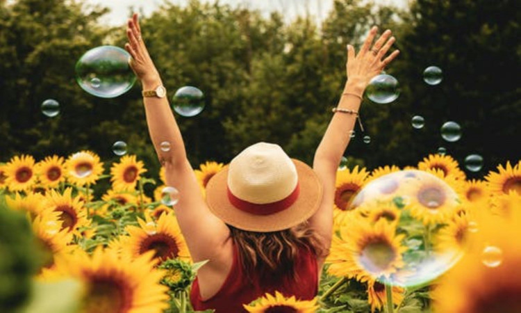 Photo of a happy woman surrounded with flowers.