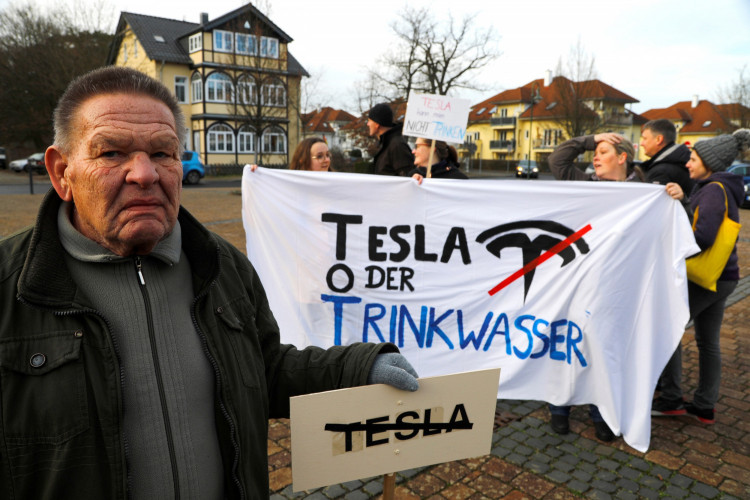 Demonstrators hold anti-Tesla posters during a protest against plans by U.S. electric vehicle pioneer Tesla to build its first European factory and design center near Berli