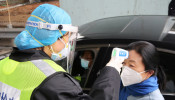 A security officer in a protective mask checks the temperature of a passenger following the outbreak of a new coronavirus, at an expressway toll station on the eve of the Chinese Lunar New Year celebrations, in Xianning