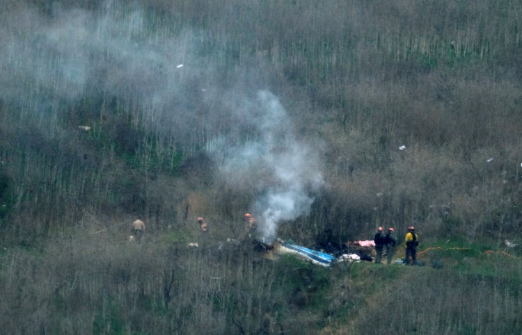 Law enforcement officers investigate on the scene of a helicopter crash that killed retired basketball star Bryant in Calabasas
