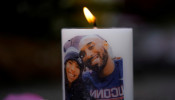 NBA basketball star Kobe Bryant and his daughter Gianna's image are shown on a burning candle as fans pay their respects at a memorial outside the Staples Center at L.A. Live in Los Angeles