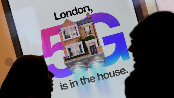 Pedestrians walk past an advertisement promoting the 5G data network at a mobile phone store in London, Britain, January 28, 2020. 