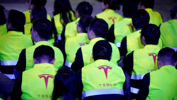Employees of Tesla are seen during a delivery event for Tesla China-made Model 3 cars in Shanghai