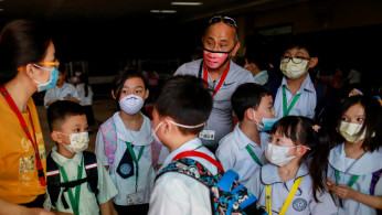 Guardians and students wear masks amid a health scare over a new virus that has infected thousands since emerging in China, in a Chinese school in Quezon City, Metro Manila, Philippines