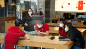 People wear face masks as they listen to a presentation in an Apple Store in the Sanlitun shopping district in Beijing as China is hit by an outbreak of the new coronavirus