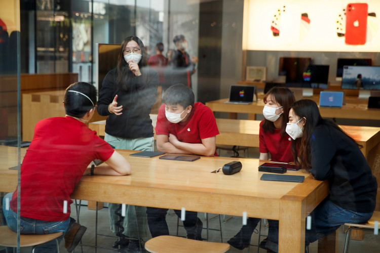 People wear face masks as they listen to a presentation in an Apple Store in the Sanlitun shopping district in Beijing as China is hit by an outbreak of the new coronavirus