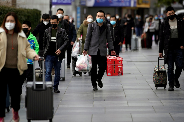 Passengers wearing masks walk outside the Shanghai railway station in Shanghai, China, as the country is hit by an outbreak of a new coronavirus