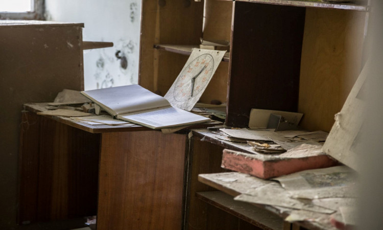 Open book on brown wooden desk.