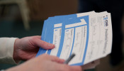 An Iowa Caucus precinct worker counts Iowa Democratic Caucus paper ballots 