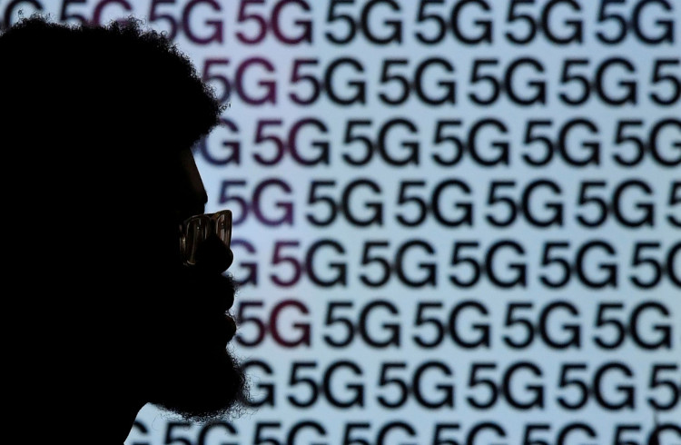 A man walks past an advertisement promoting the 5G data network at a mobile phone store in London, Britain, January 28, 2020. 