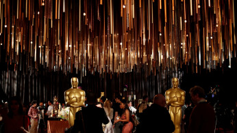 People stand by Oscar statues during a media preview of this year's Academy's Governors Ball in Los Angeles, California