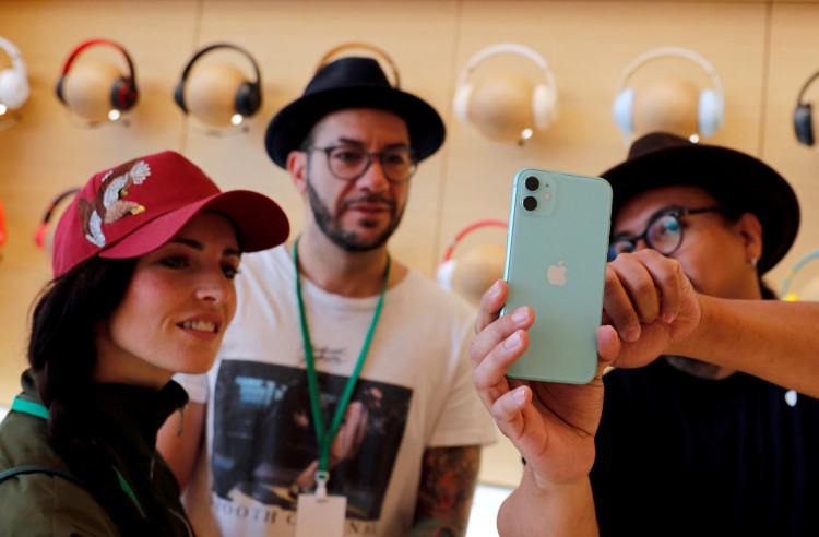 People look at an app on the new iPhone inside the new Apple Store in Mexico City