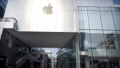 Man wearing a face mask walks past a closed Apple store at Sanlitun in Beijing