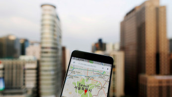 Google Maps application is displayed on a smartphone as central Seoul is seen in the background in Seoul, South Korea, in this photo illustration on August 24, 2016. 