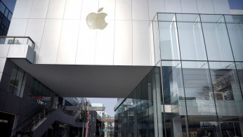 A man wearing a face mask walks past a closed Apple store at Sanlitun, as the country is hit by an outbreak of the new coronavirus, in Beijing