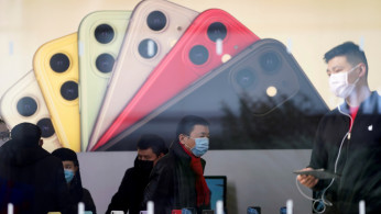 FILE PHOTO: People wearing protective masks are seen in an Apple Store, as China is hit by an outbreak of the new coronavirus, in Shanghai