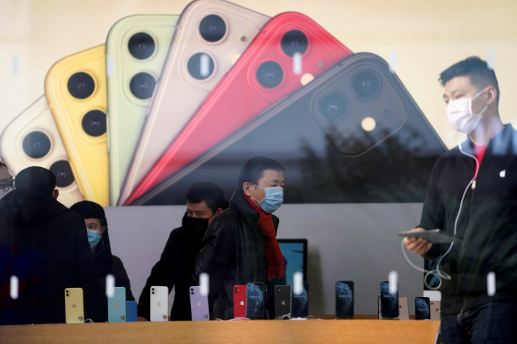 FILE PHOTO: People wearing protective masks are seen in an Apple Store, as China is hit by an outbreak of the new coronavirus, in Shanghai