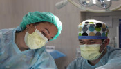 Surgeons performing surgery with surgical masks on.