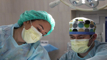 Surgeons performing surgery with surgical masks on.