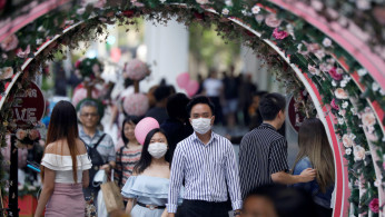 A couple celebrate Valentine's Day as they wear face masks in precaution of the coronavirus outbreak at Orchard Road in Singapore