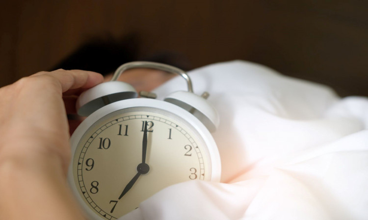 Person holding an alarm clock.