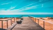 Brown wooden dock in a magnificent view of the ocean. 