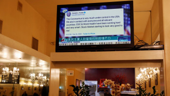 A tweet by U.S. Donald Trump regarding the coronavirus is seen on a Chinese television station inside a restaurant in the Chinatown section of San Francisco, California