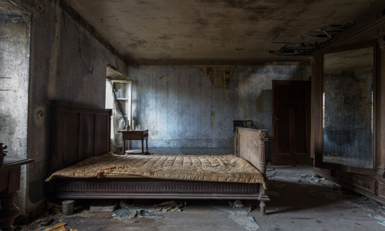 Empty damaged room with a mattress.