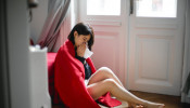Woman with flu sitting on the floor.