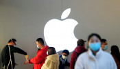 People wearing protective masks wait for checking their temperature in an Apple Store in Shanghai