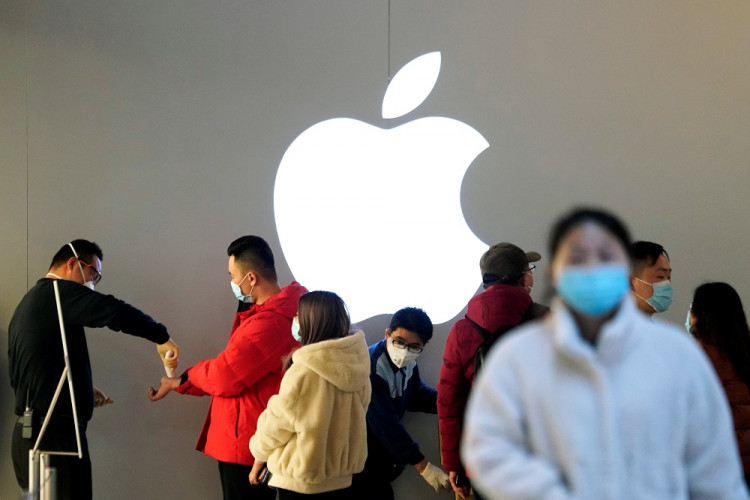 People wearing protective masks wait for checking their temperature in an Apple Store in Shanghai