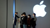 People wearing protective masks wait for checking their temperature in an Apple Store, in Shanghai
