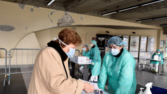 Medical workers wearing protective masks check patients at a medical checkpoint at the entrance of the Spedali Civili hospital in Brescia
