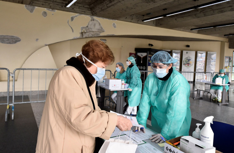 Medical workers wearing protective masks check patients at a medical checkpoint at the entrance of the Spedali Civili hospital in Brescia